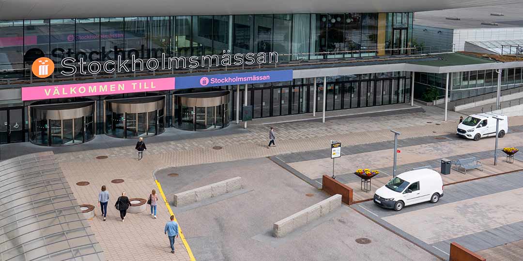 picture of the entrance to the stockholm fair with people and cars moving outside the entrance.