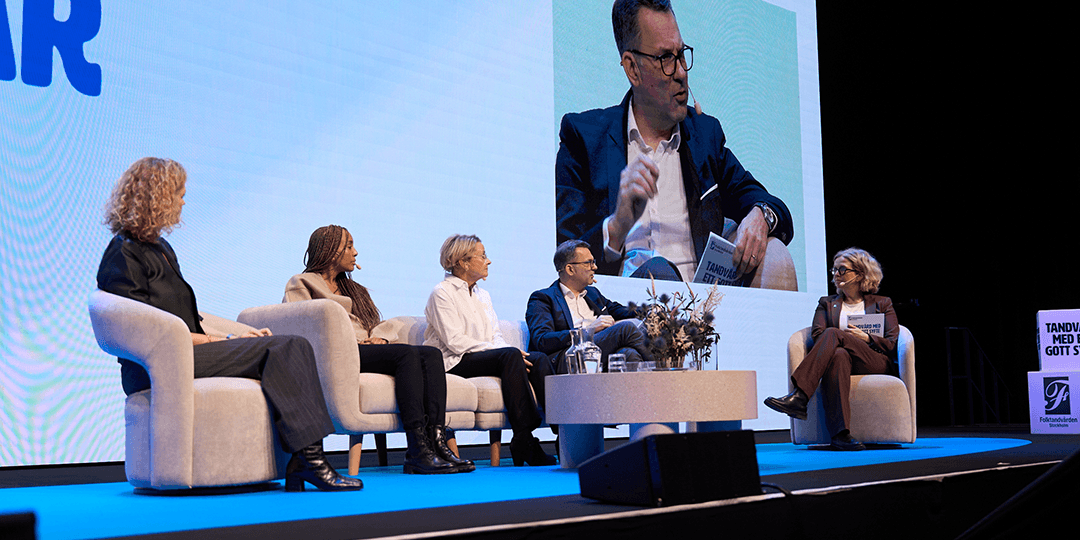Five speakers in a panel discussion on stage in front of an audience, with a large screen backdrop during a kick-off in Victoria Hall at Stockholmsmässan.