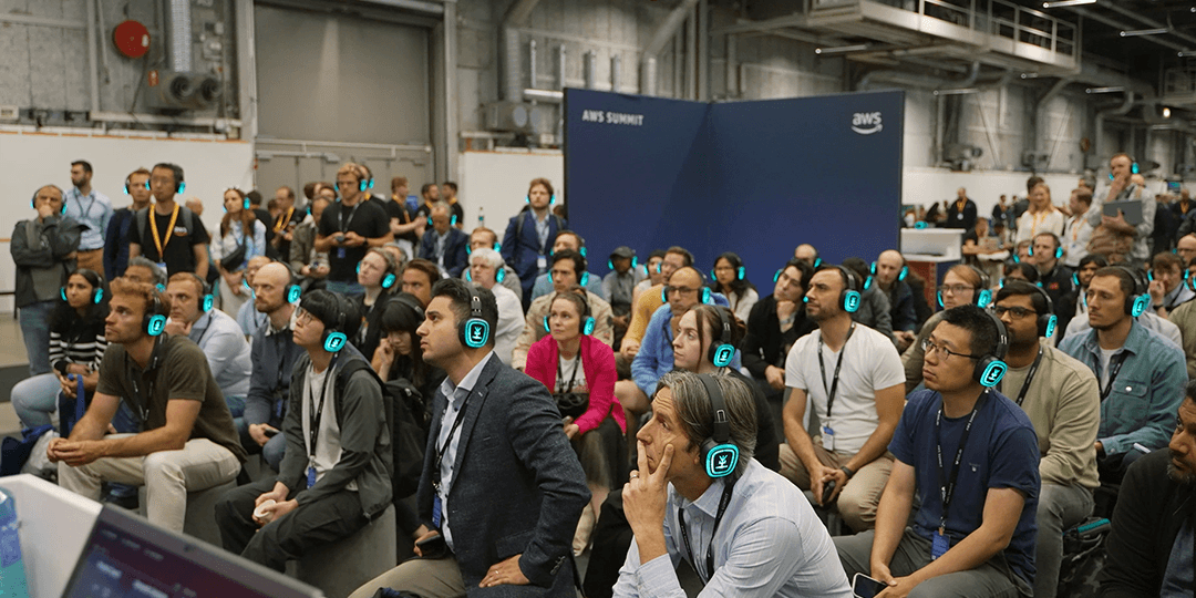 Participants with headphones listening to a lecture during AWS Summit Stockholm.