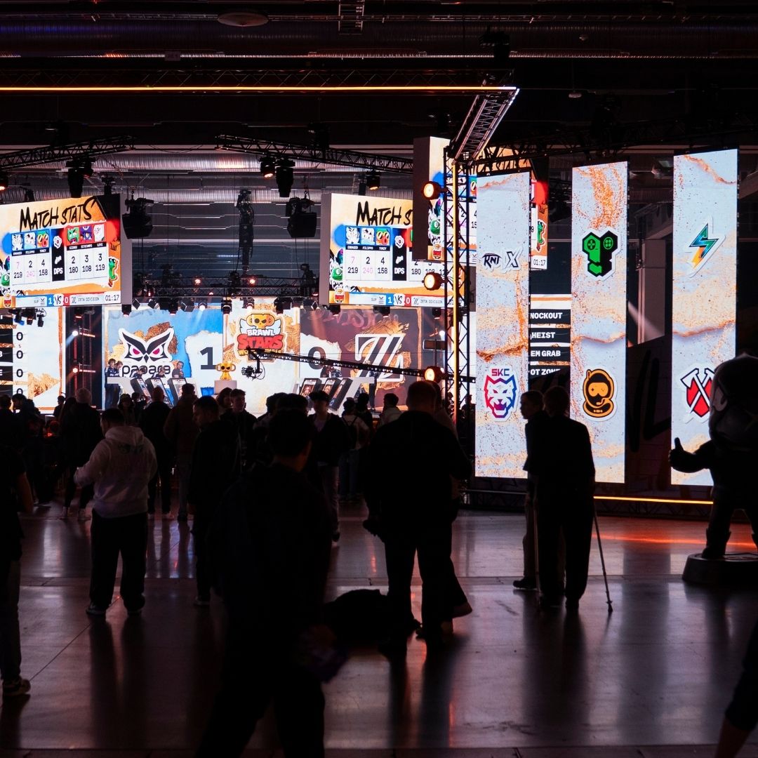Besökare i eventhall med stora skärmar under ett esportevent.