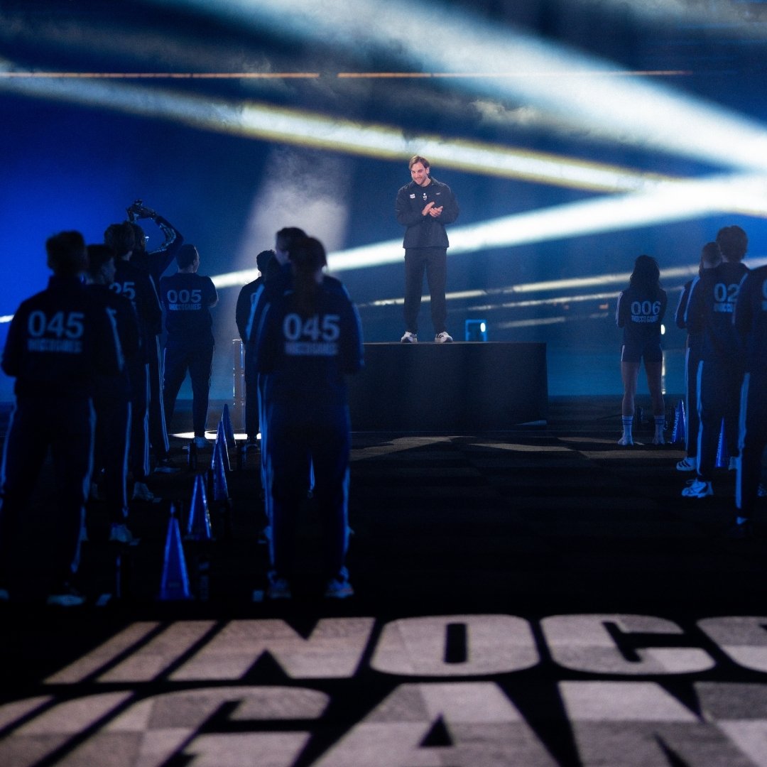 Visitors in an event hall with large screens during an esports event.